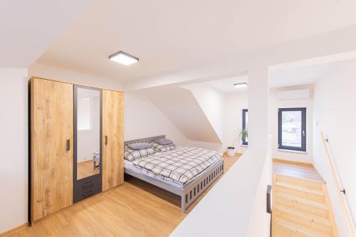 ein Schlafzimmer mit einem Bett in einem weißen Zimmer in der Unterkunft Rezidence Novosadská in Olomouc