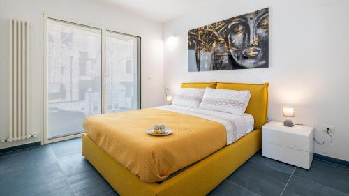 Un dormitorio con una cama amarilla y un cuadro en la pared. en VILLA RISTOLA 6, Emma Villas, en Leuca