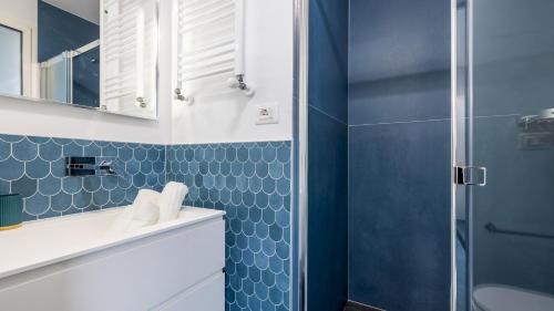 baño con ducha y pared de azulejos azules en VILLA RISTOLA 6, Emma Villas, en Leuca