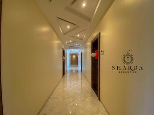 a hallway of a building with a sign on the wall at hotel sharda excutive 