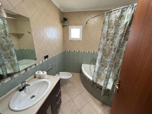 a bathroom with a sink and a tub and a toilet at Book Jet - Villa Vacacional libertad Pajara 