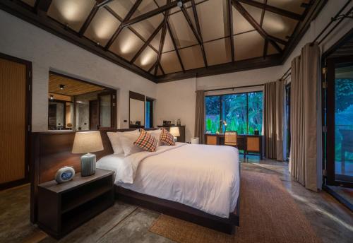 a bedroom with a large bed and a large window at Phapok Eco Resort in Ratchaburi