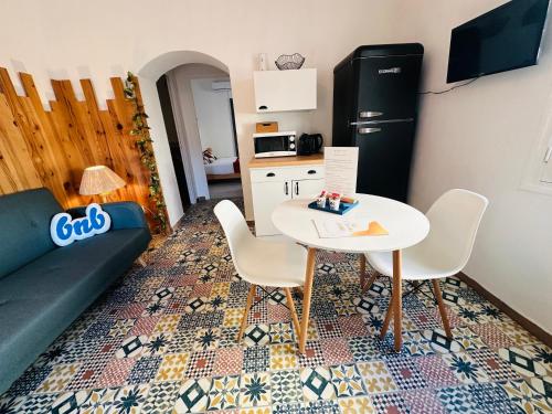 a living room with a table and a refrigerator at "T2 Ludria" au cœur de Solenzara petite vue mer in Sari Solenzara