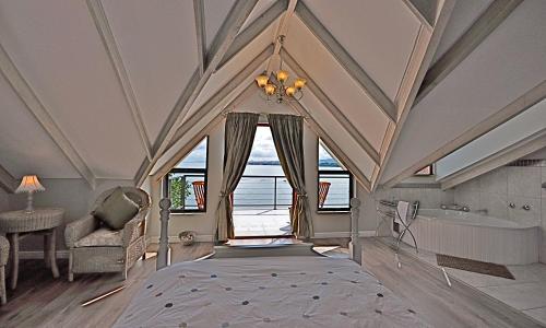 a bedroom with a ceiling with a window and a tub at Driftwood Beach Villa in Gordonʼs Bay