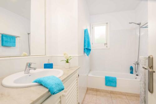 a white bathroom with a sink and a bath tub at Villa Tia Dora in Cala en Blanes