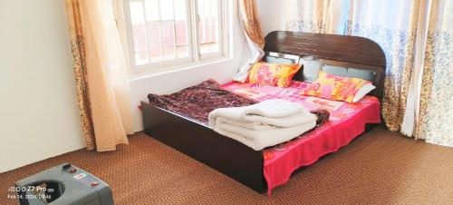 małe łóżko w pokoju z oknem w obiekcie MAGRAY GUEST HOUSE w mieście Tangmarg