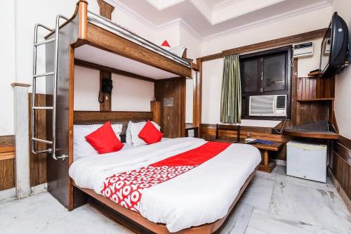 - une chambre avec un grand lit et des oreillers rouges dans l'établissement Hotel Cottage Crown Plaza By My Rooms, à New Delhi