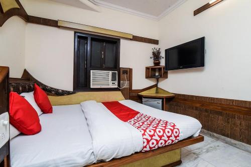 - une chambre avec un lit et une télévision à écran plat dans l'établissement Hotel Cottage Crown Plaza By My Rooms, à New Delhi