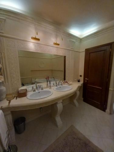 Un baño con dos lavabos y un espejo grande. en Villa Il Matto, en Arezzo