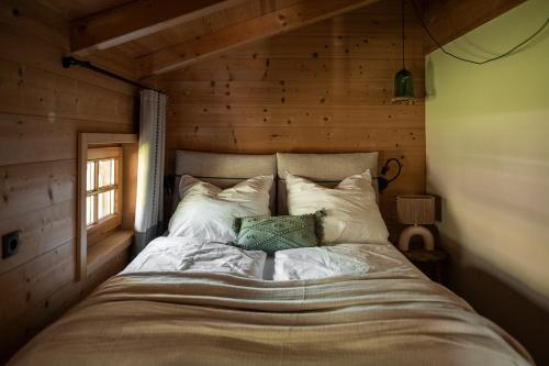 a bed in a room with a wooden wall at Oberortlhof - Juval in Kastelbell-Tschars