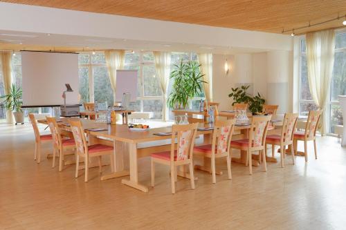 a dining room with a long table and chairs at Hotel Restaurant Talblick in Bad Ditzenbach