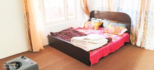 ein kleines Bett in einem Zimmer mit Fenster in der Unterkunft MAGRAY GUEST HOUSE in Tangmarg
