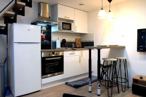 une cuisine avec un réfrigérateur blanc et un comptoir dans l'établissement L impérial 5 - Direct Gare- 35 mn Paris, à Étampes