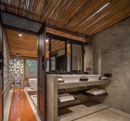 a bathroom with a large sink and a tub at Phapok Eco Resort in Ratchaburi