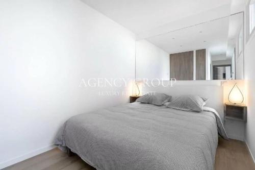 ein Schlafzimmer mit einem großen Bett und zwei Lampen in der Unterkunft Appartement T2, proche Croisette in Cannes