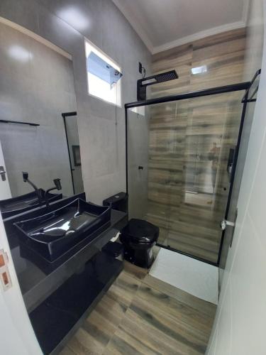 a bathroom with a sink and a glass shower at Pousada & Hotel Fazenda Segredo Das Águas in Alto Caparao