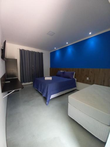 a bedroom with a bed and a blue wall at Pousada & Hotel Fazenda Segredo Das Águas in Alto Caparao