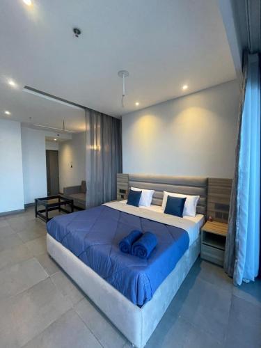 a bedroom with a large bed with blue pillows at Skystay in Greater Noida