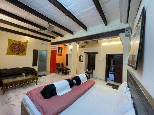 Cama grande en habitación con sofá en Suraj Guest House, en Varanasi
