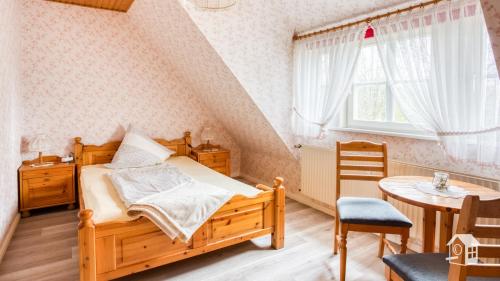 Un dormitorio con una cama de madera y una mesa. en De ole Spieker, en Munster im Heidekreis