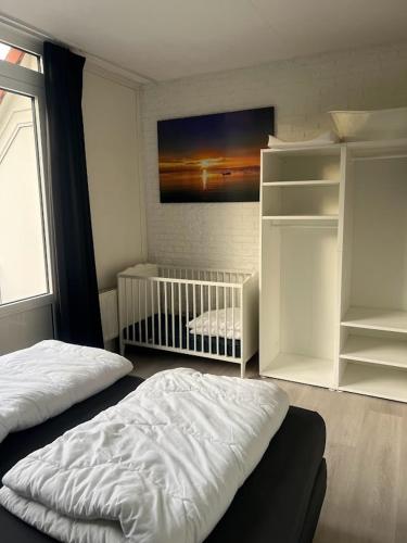 a bedroom with a bed and a crib in it at De Tureluur Bruinisse in Bruinisse