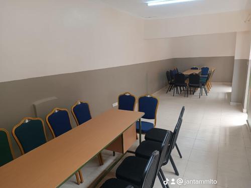 una sala de conferencias con sillas, mesas y una mesa larga en The white rock 2023, en Eldoret