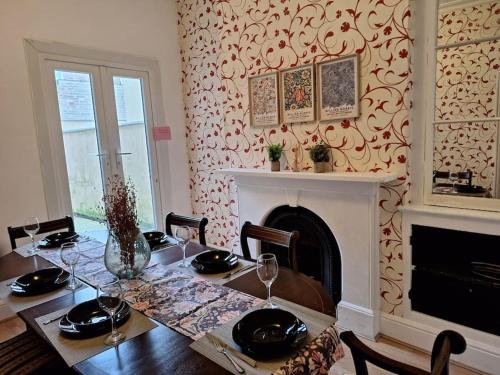 a dining room with a table and a fireplace at Anfield Abbey House in Liverpool