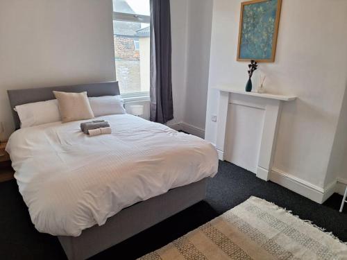 - une chambre avec un lit blanc et une cheminée dans l'établissement Anfield Abbey House, à Liverpool