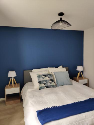 Un dormitorio con una pared azul y una cama en Grande Maison Proche Aéroport, en Beauvais
