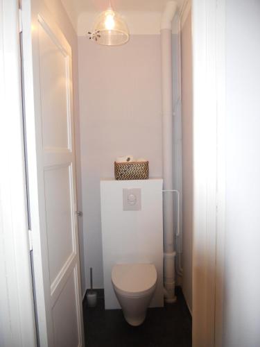 La salle de bains est pourvue de toilettes blanches et d'une porte. dans l'établissement Le Saint-François, à Saint-Malo