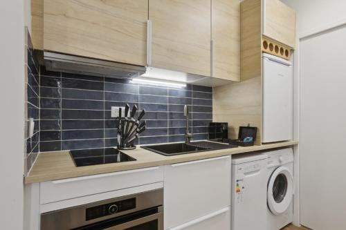 862 Suite Tulipe - Superb apartment في مونتروي: مطبخ مع مغسلة وغسالة ملابس