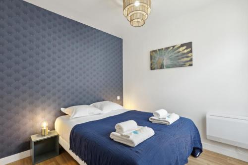 862 Suite Tulipe - Superb apartment في مونتروي: غرفة نوم بسرير ازرق عليها مناشف