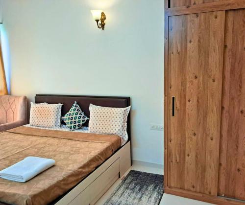 une petite chambre avec un lit et une porte en bois dans l'établissement Pool view 2BHK 10 min to GOI airport & beach, à Dabolim