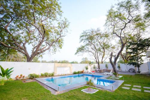 The Neem Tree -4br pool villa في شاميربت: مسبح في ساحه فيها اشجار