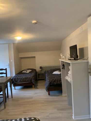 a living room with two beds and a table at Auberge Alsacienne in Bussang