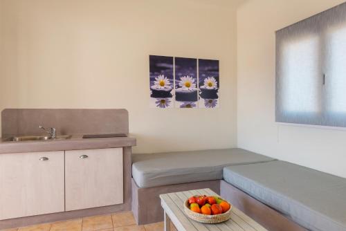 a living room with a couch and a bowl of fruit at Aegean Paradiso Vacation Club - "Adults Only" in Azolimnos