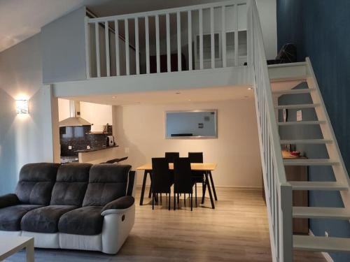 a living room with a couch and a dining room at Joli appartement dans quartier calme de Perpignan in Perpignan