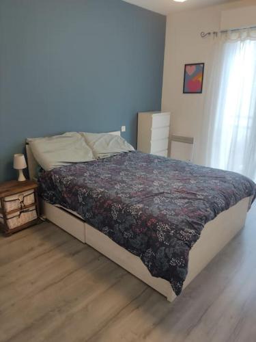 - une chambre avec un grand lit et une couverture fleurie dans l'établissement Joli appartement dans quartier calme de Perpignan, à Perpignan