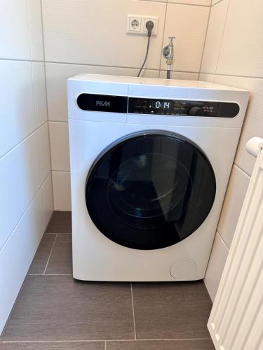 a white microwave sitting on the floor in a kitchen at FlexHome Moderne Ferienwohnung in Lippstadt