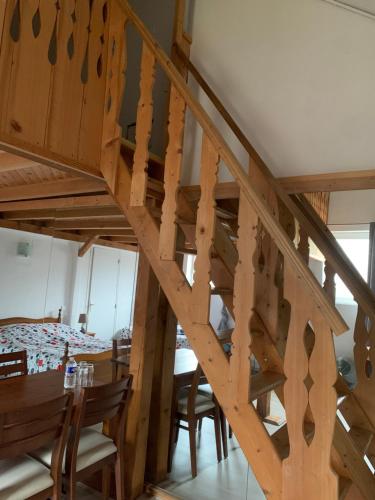 a wooden staircase in a room with a table and chairs at Auberge Alsacienne in Bussang