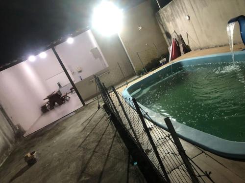 an empty swimming pool at night in a building at Casa temporada marechal Deodoro in Marechal Deodoro