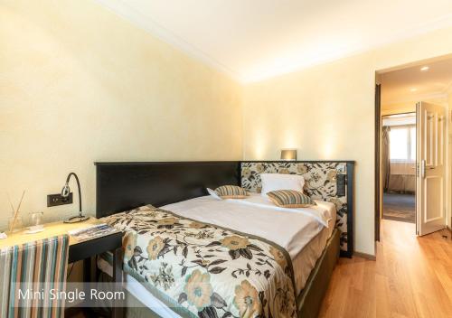 a bedroom with a large bed and a desk at Lenkerhof gourmet spa resort - Relais & Châteaux in Lenk