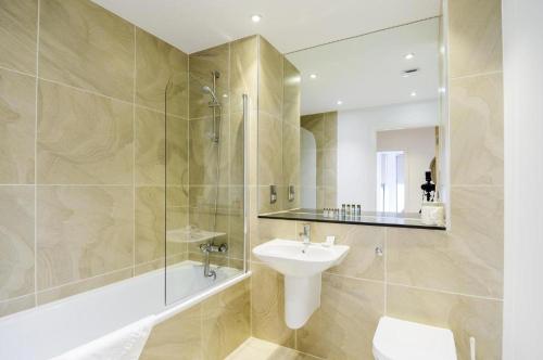 een badkamer met een wastafel en een douche met een spiegel bij Large 2 Bed Apartment London Catford Lewisham - Perfect for Long Stays in Londen