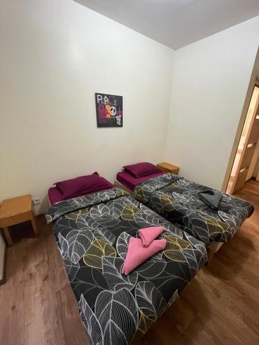 sypialnia z 2 łóżkami i różowymi poduszkami w obiekcie Hôtel Lyonnais w Nicei