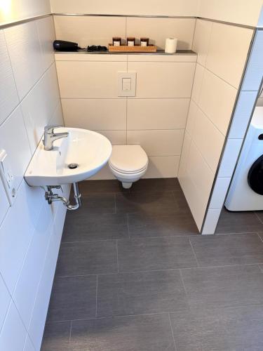 a bathroom with a sink and a toilet at FlexHome Moderne Ferienwohnung in Lippstadt