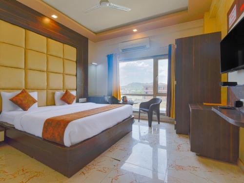 Habitación de hotel con cama y ventana grande en Mangal Residency Rooftop Pool, en Udaipur