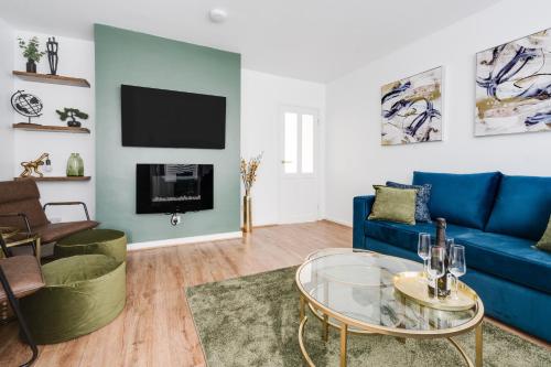 a living room with a blue couch and a table at Leyland House - Private Parking Free Wi-Fi Garden in Leyland