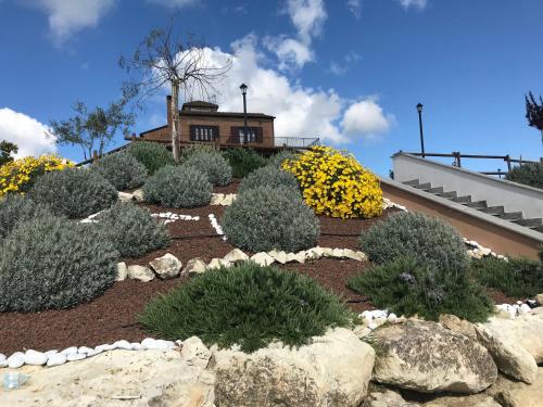 a garden with bushes and rocks in front of a house at Love Nests by The Bell Tower Lodge in Palidoro