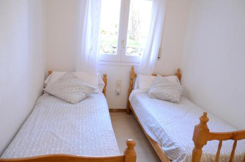 - 2 lits dans une petite chambre avec 2 fenêtres dans l'établissement Petunies, à Platja d'Aro