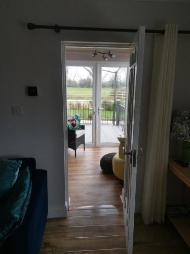 a living room with a door open to a deck at Tranquil unit close to Kells in Kilkenny